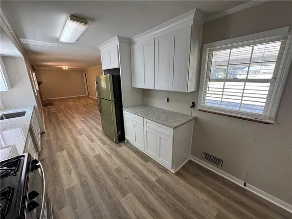 a kitchen with wooden floors and white cabinets