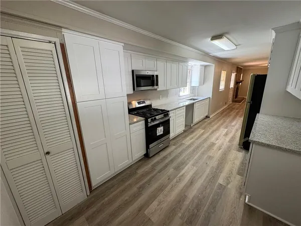a kitchen with stainless steel appliances a refrigerator a sink a stove top oven a counter space and cabinets
