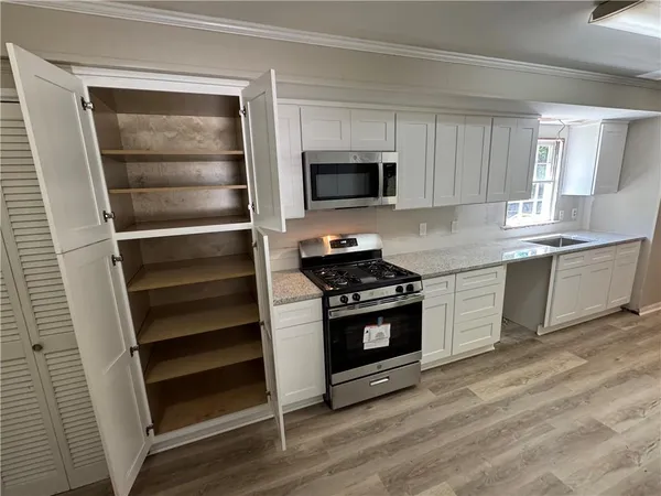 a kitchen with granite countertop white cabinets and stainless steel appliances