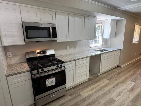 a kitchen with stainless steel appliances granite countertop a stove microwave and sink