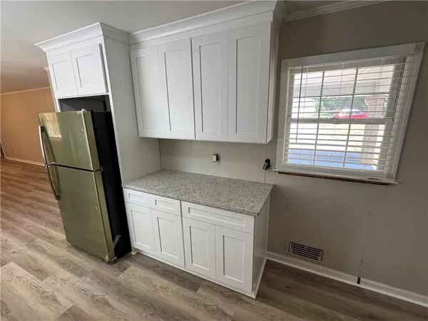 a kitchen with granite countertop a refrigerator a sink and a stove