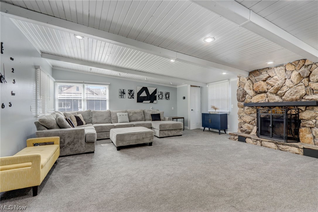 19480 Drake Road Strongsville, OH 44149 - Photo 11 of 39 Living room with light carpet, a stone fireplace, and beam ceiling
