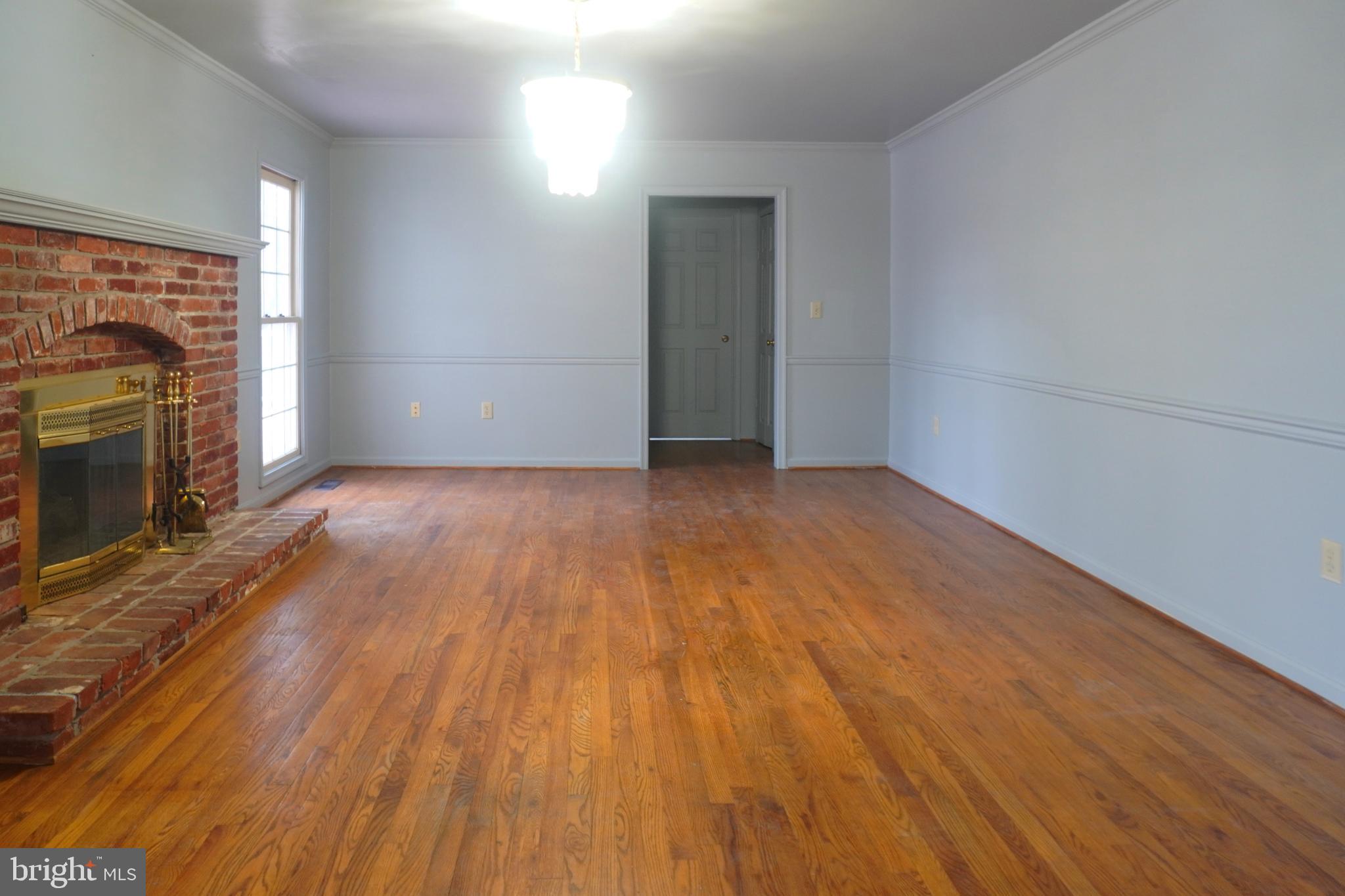 1509 Baytree Terrace Bowie, MD 20721 - Photo 18 of 45 an empty room with wooden floor fireplace and windows