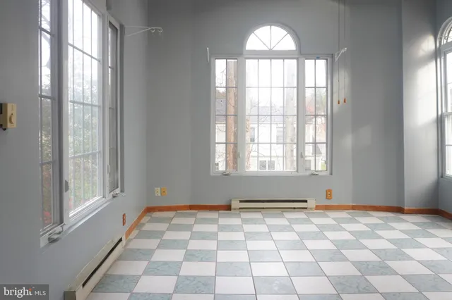 a white toilet sitting next to a white wall