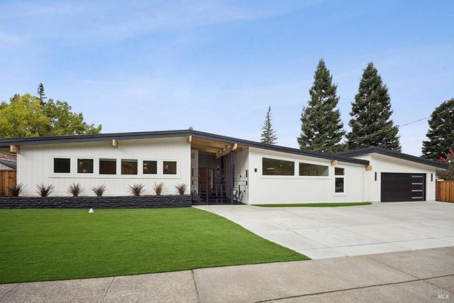 a front view of a house with a garden and yard