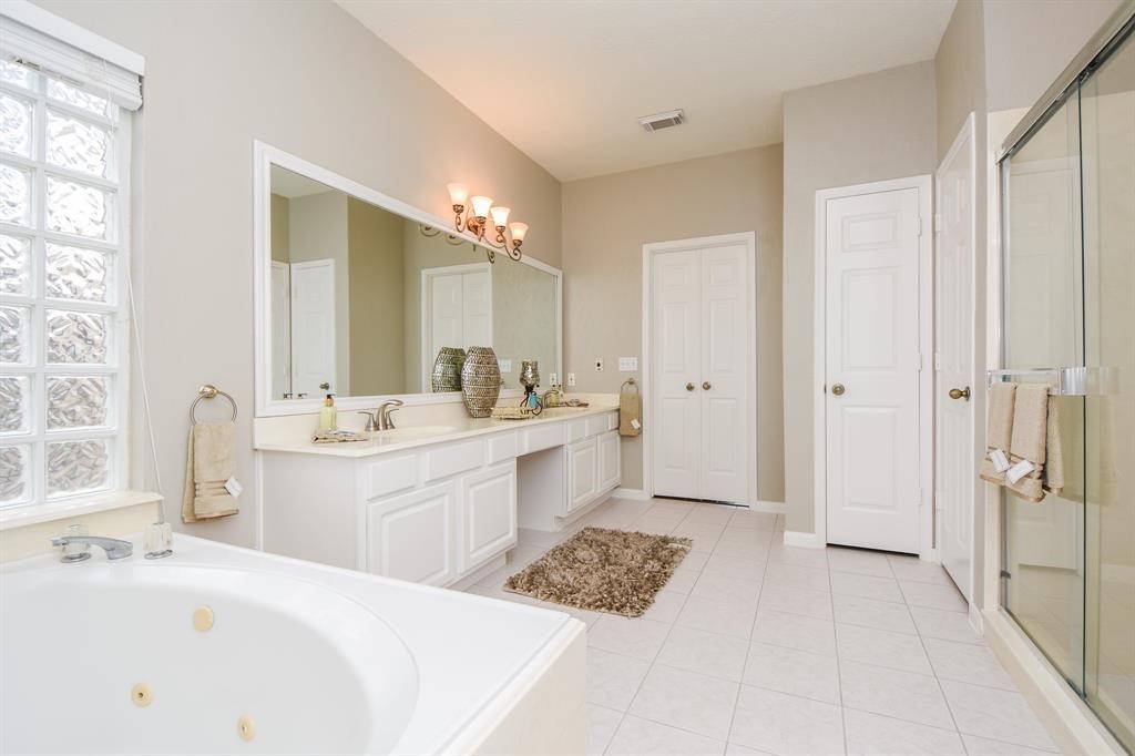 27 West Rumple Creek Place Spring, TX 77381 - Photo 18 of 32 Complete with a private powder room, double sinks, and a jetted tub this bathroom is sure to impress!