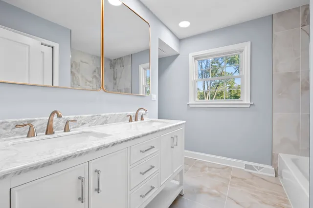 a bathroom with a granite countertop sink mirror and vanity