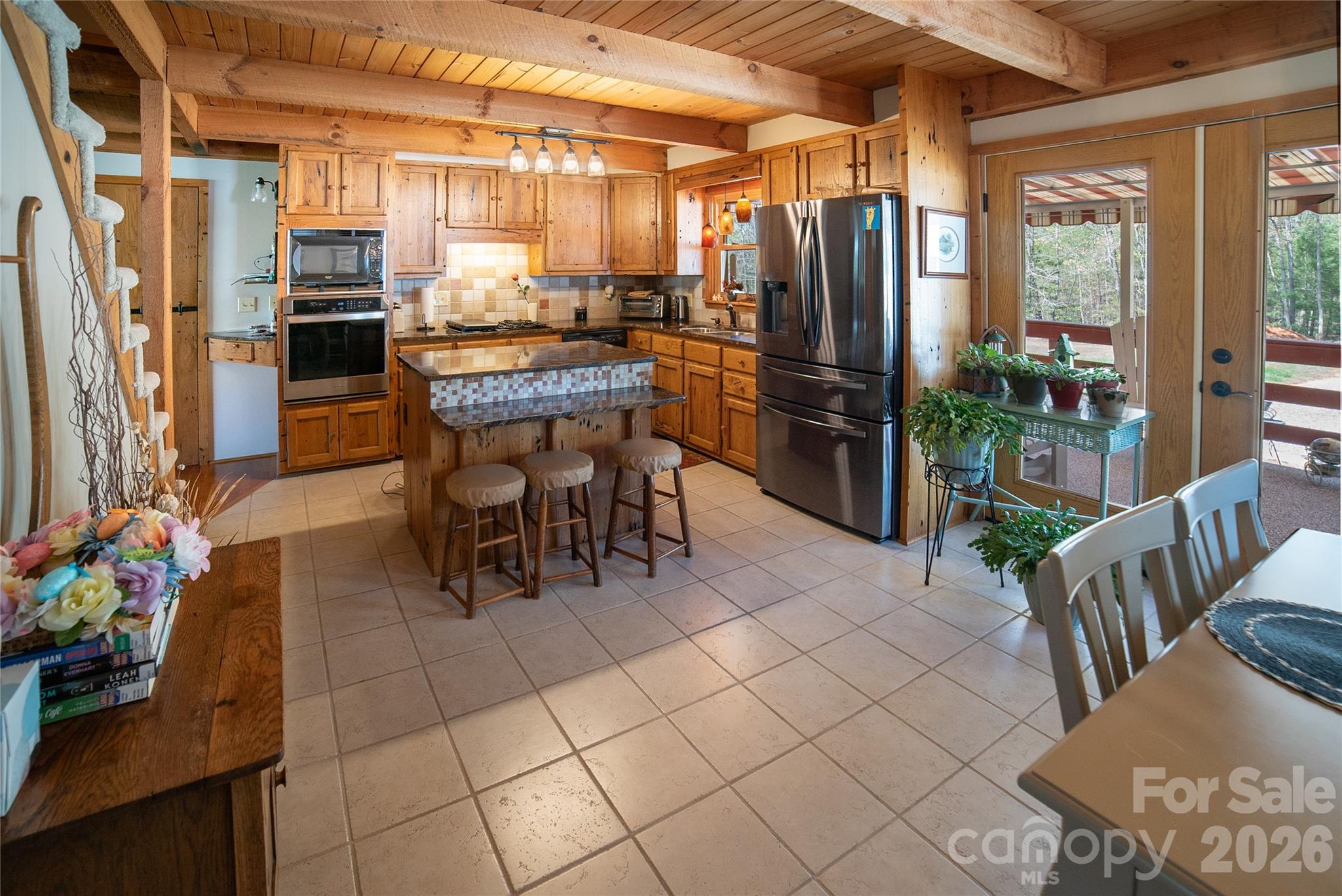 1368 Cajah Mountain Road Hudson, NC 28638 - Photo 15 of 39 a dining hall with stainless steel appliances kitchen island granite countertop a refrigerator a stove and a dining table with large windows