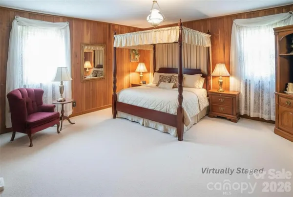 a bed room with furniture a window and a flat screen tv