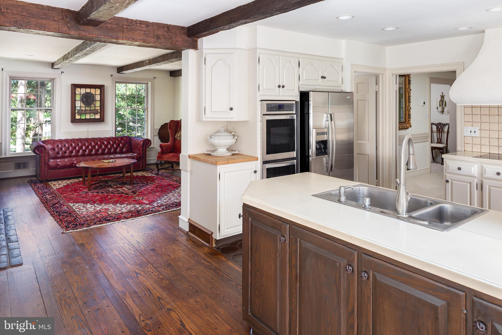8 Fox Chase Road Malvern, PA 19355 - Photo 15 of 49 a living room with stainless steel appliances kitchen island granite countertop a refrigerator a sink dishwasher and white cabinets with wooden floor