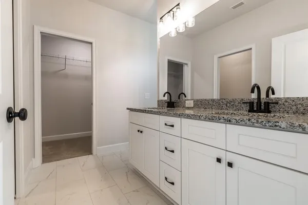 a bathroom with a granite countertop sink a mirror and a vanity