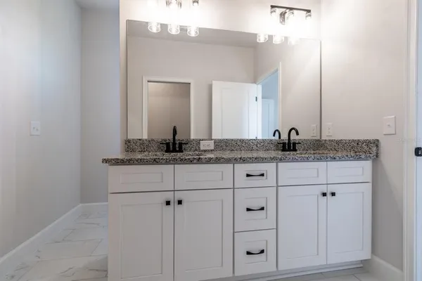 a bathroom with a granite countertop sink and a mirror