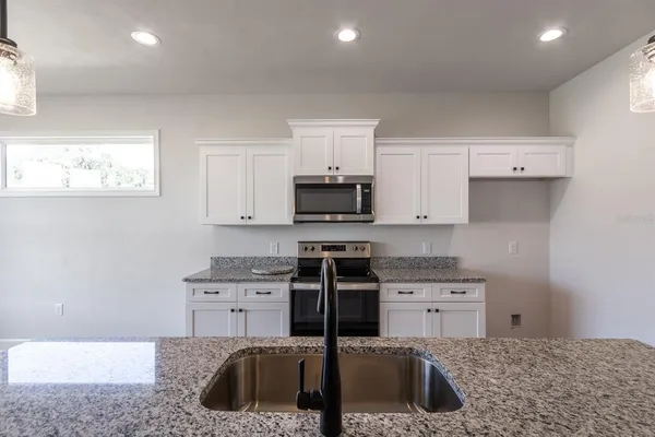 a kitchen with a sink cabinets and stainless steel appliances