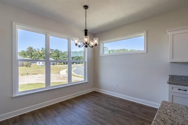 a view of a livingroom with a chandelier wooden floor and a chandelier