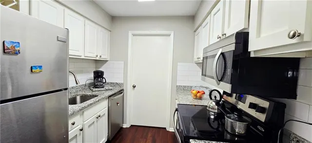 a kitchen with a sink appliances and cabinets