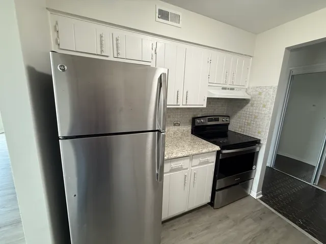 a kitchen with wooden floors and appliances