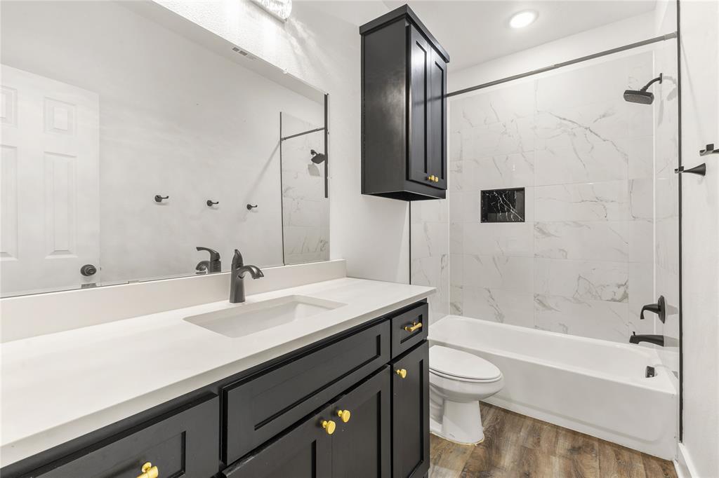101 Ross Street Sulphur Springs, TX 75482 - Photo 19 of 30 Bathroom with vanity, bathtub / shower combination, and dark wood-style floors