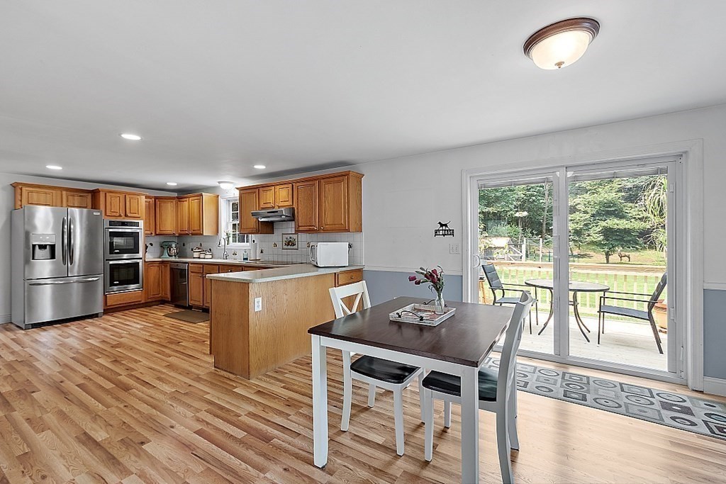 454 Loring Road Barre, MA 01005 - Photo 6 of 42 a kitchen with a table chairs refrigerator and cabinets