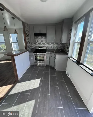 a kitchen with a sink a counter top space cabinets and stainless steel appliances