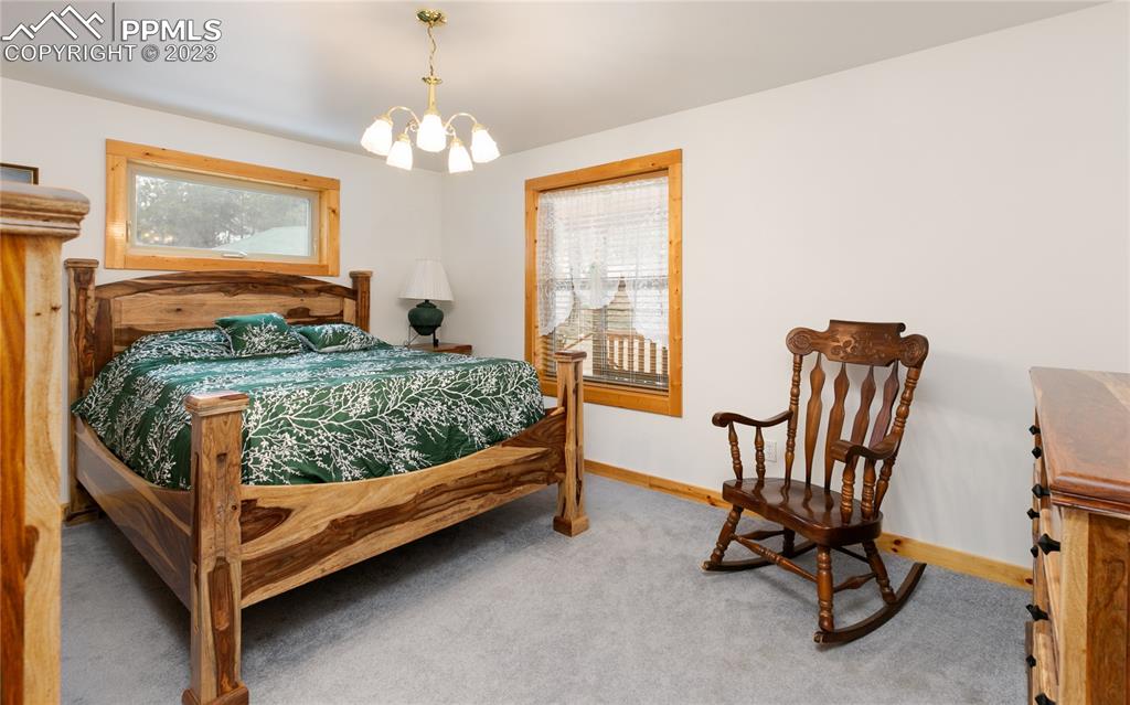 1321 Bristlecone Road Guffey, CO 80820 - Photo 22 of 37 a bedroom with a bed and a chandelier