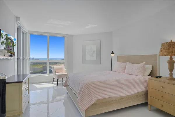 a bedroom with a large bed and a large window