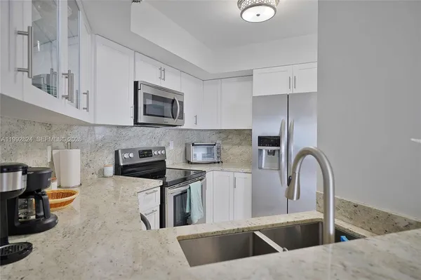 a kitchen with stainless steel appliances granite countertop a sink a stove and a microwave