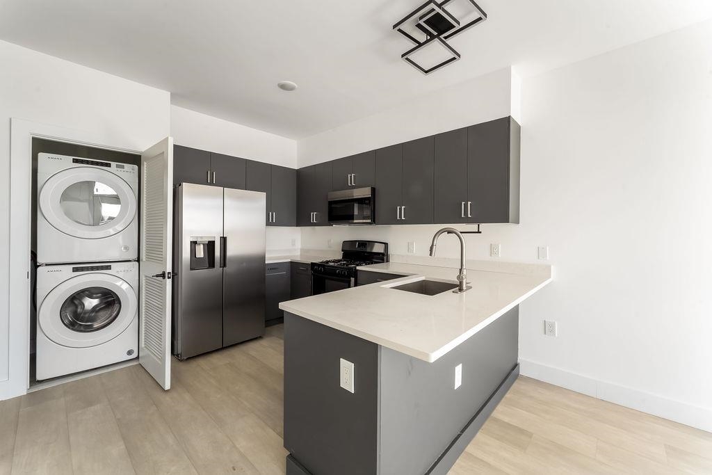 43-45 West 32nd Street, Unit 503 Bayonne, NJ 07002 - Photo 4 of 19 a kitchen with a sink a stove and a microwave
