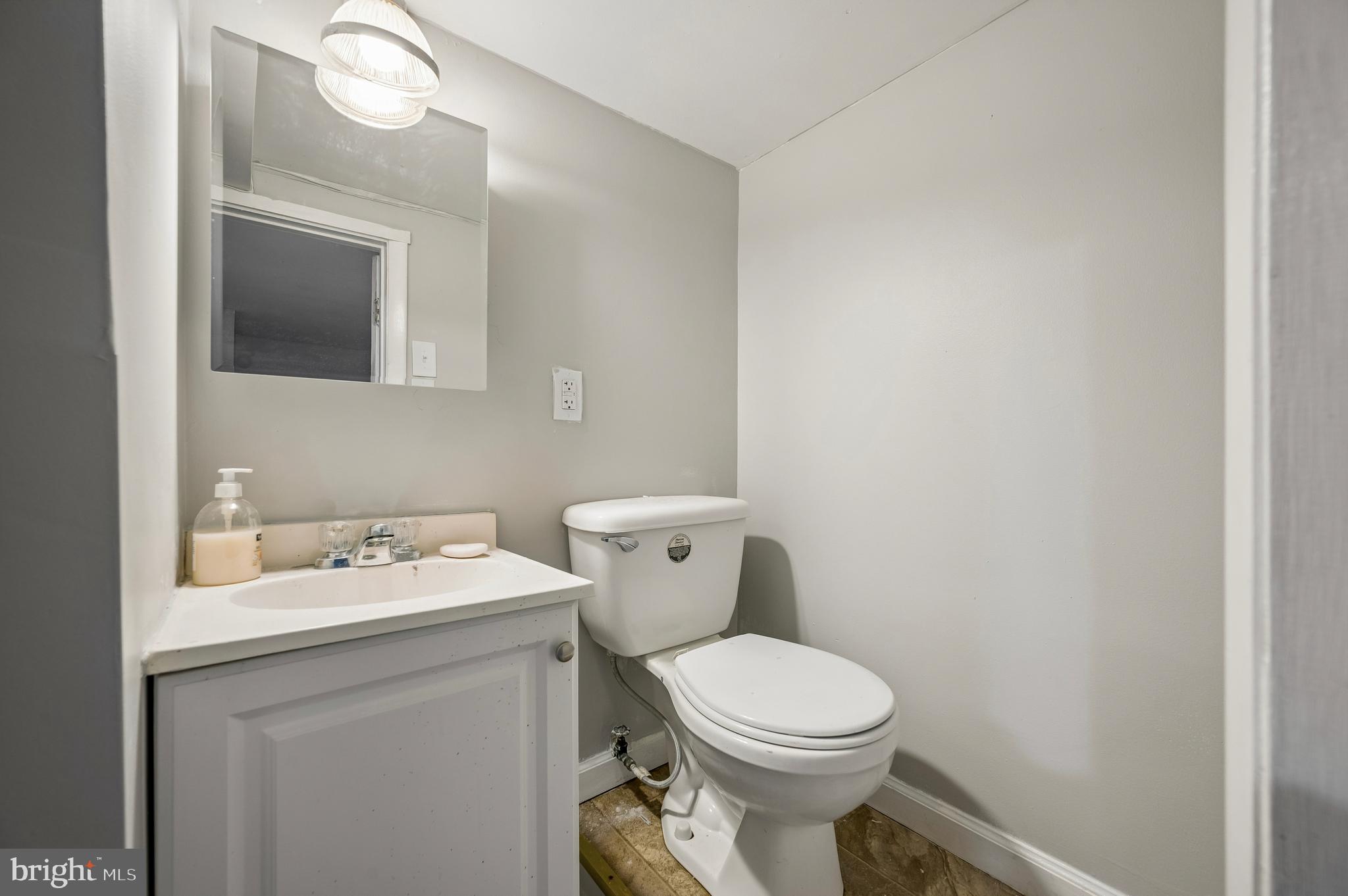 5625 Willows Avenue Philadelphia, PA 19143 - Photo 15 of 15 a bathroom with a toilet sink and mirror