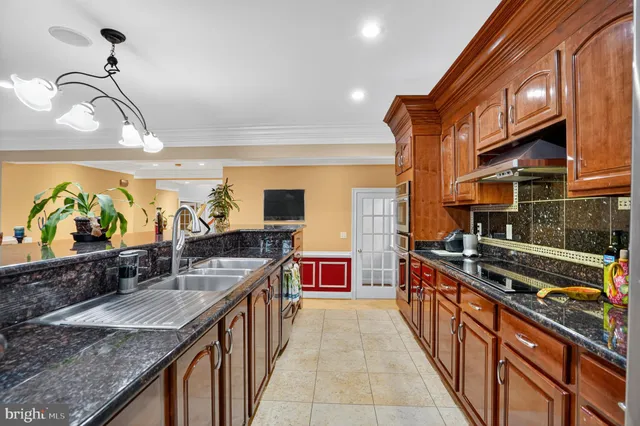 a kitchen with stainless steel appliances granite countertop a sink and a wooden cabinets