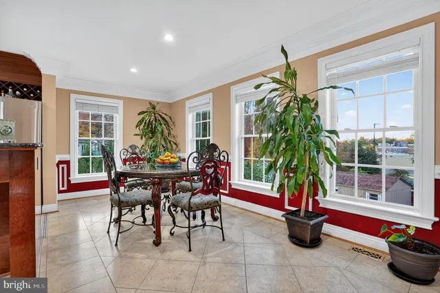 a dining room filled with furniture and potted plants