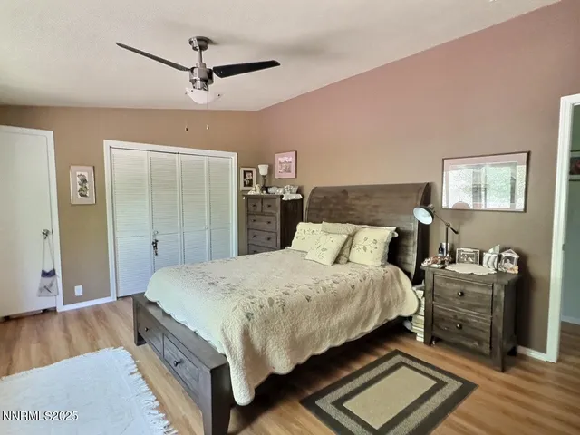a bedroom with a bed and a table with wooden floor