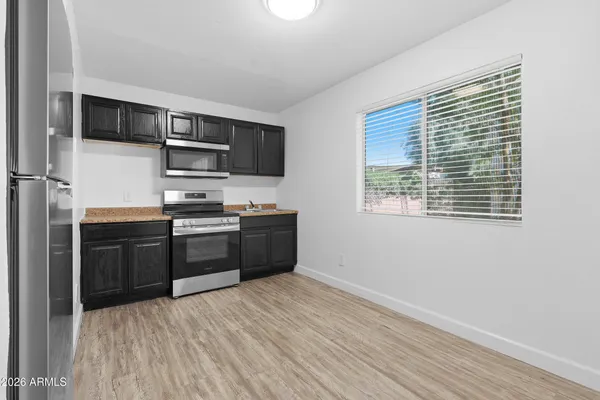 a kitchen with stainless steel appliances granite countertop a stove a sink and a microwave