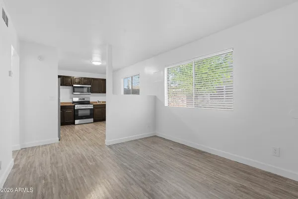 a view of a kitchen with wooden floor and electronic appliances