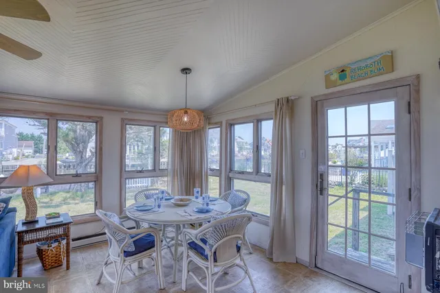 a view of a dining room with furniture large windows and wooden floor