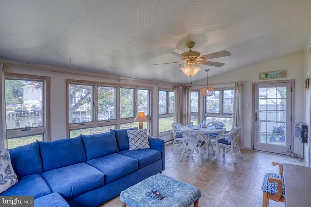 a living room with furniture large window and wooden floor