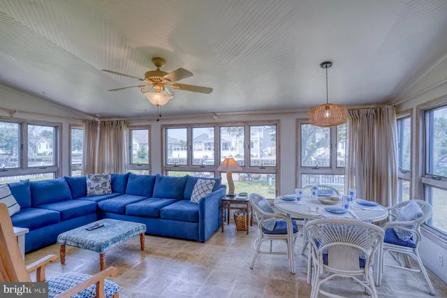 a living room with furniture a large window and a chandelier