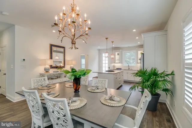 a kitchen with refrigerator a stove a sink and white cabinets with wooden floor