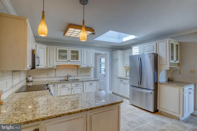 a kitchen with stainless steel appliances granite countertop a sink refrigerator and cabinets