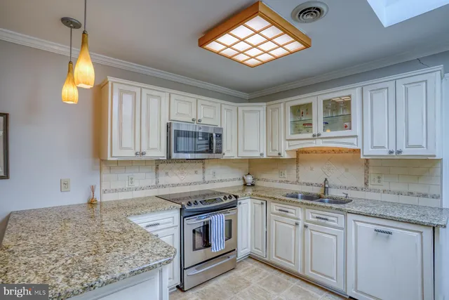 a kitchen with stainless steel appliances granite countertop a sink stove and cabinets