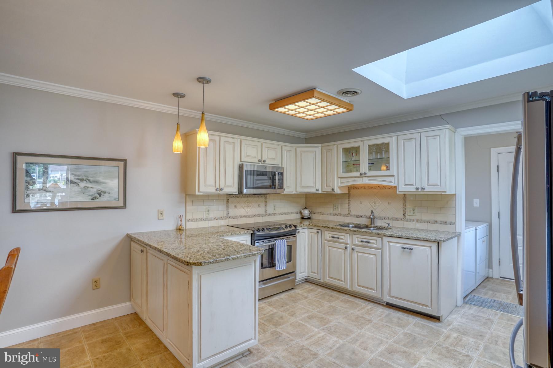 28 Marshall Road Rehoboth Beach, DE 19971 - Photo 9 of 60 a kitchen with a sink stove and cabinets