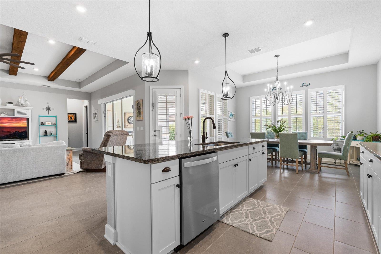 122 Kendall Way Street St. Augustine, FL 32092 - Photo 11 of 40 a large kitchen with kitchen island a large counter space a chandelier and living room view