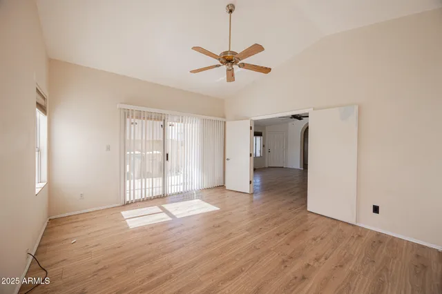 a view of a room with wooden floor and ceiling fan