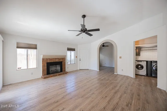 a view of empty room with a fireplace and wooden floor