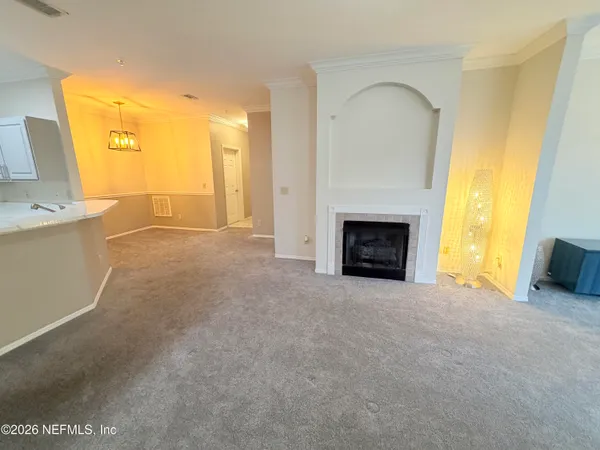 a view of empty room with a fireplace and a window