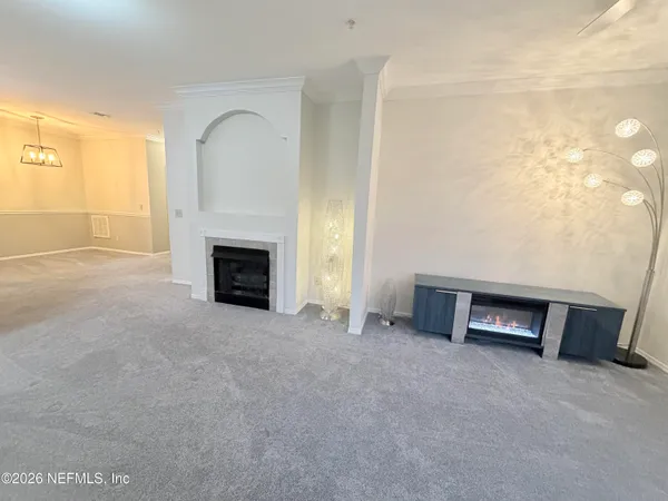 a view of an empty room with a fireplace and a window