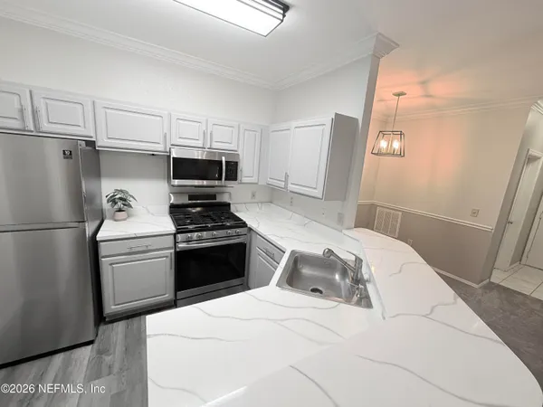 a bedroom with a bed and a refrigerator