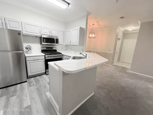 a kitchen with stainless steel appliances a refrigerator a stove a microwave and island