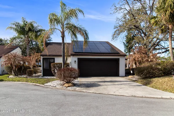 a front view of a house with yard and trees
