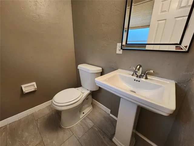 a bathroom with a sink a toilet and mirror