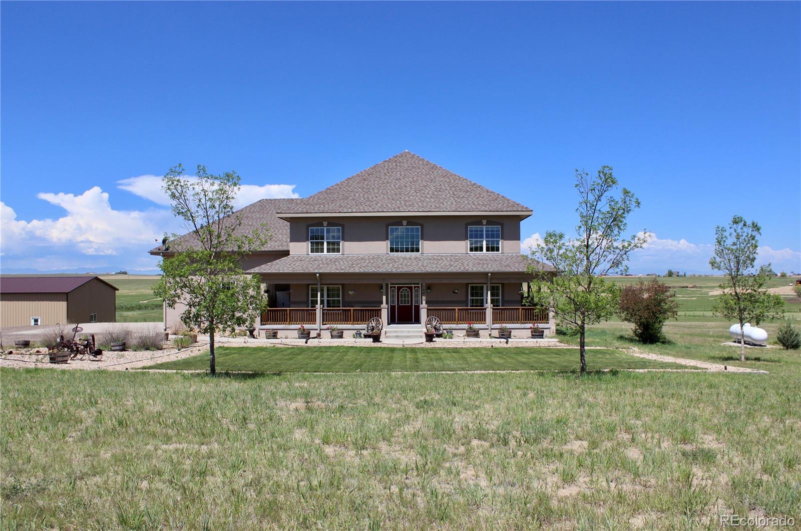 14855 Almstead Street Hudson, CO 80642 - Photo 1 of 39 a front view of a house with garden